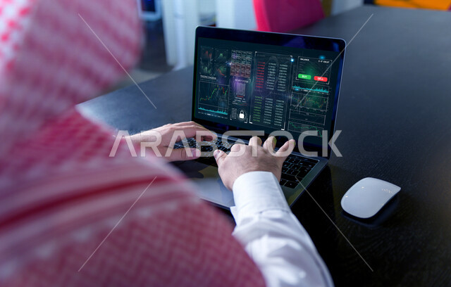 صورة مقربة ليد رجل عربي خليجي سعودي في مقر عمله بالشركة، يتابع البورصة من خلال استخدام الابتوب، العمل من خلال الحاسوب المحمول، صعود ونزول البورصة المالية، الاستثمار المالي والاقتصادي، أعمال الكترونية تجارية