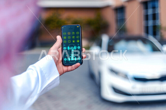 صورة مقربة ليد رجل عربي خليجي سعودي يستخدم الهاتف المحمول في تصفح تطبيق خاص بفحص قطع غيار السيارات، مجموعة من الايقونات الخاصة بقطع السيارات، فحص السيارات من خلال الهاتف المحمول، تقنيات مختلفة، خدمة تطبيق فحص قطع غيار السيارات