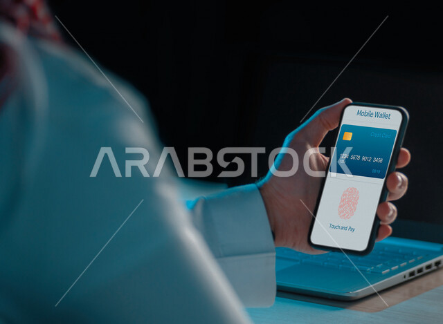 رجل عربي خليجي سعودي، خدمات الدفع الالكتورني عبر الهاتف المحمول، استخدام بطاقة ائتمان مخزنه بشكل آمن، التسوق والشراء الالكتروني، فحص بصمات الأصابع، الدخول الامن، مفهوم خصوصية بيانات المستخدم، الحفاظ على البيانات الشخصية للمستخدمينة