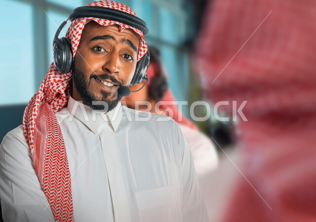 موظفان عربيان سعوديان خليجيان يعملان في خدمة العملاء في شركة يرتديان الرأس الصوتية ، العمل بالدعم الفني ، الإستعلامات والإستفسارات ، الإجابة على أسئلة العملاء ، خدمة العملاء والدعم الفني 
