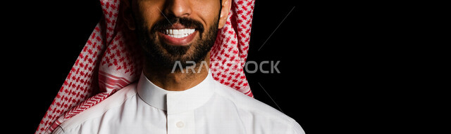 صورة مقربة لرجل عربية خليجي سعودي يبتسم إبتسامة هوليود ، تجميل و تبييض الأسنان ، أسنان جميلة ذات بياض ناصع ، معالجة الأسنان ، استخدام قشور فينير من الخزف للأسنان ، خلفية سوداء