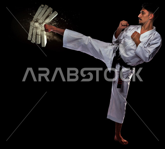 شاب عربي خليجي سعودي، يرتدي زي الكاراتيه ذات الحزام الأسود، التدرب على حركات قتالية خاصة برياضة الكاراتيه، فنون قتالية يابانية، رياضات الألعاب الأولمبية، نادي رياضي، رياضة الكاراتيه في السعودية، بطولات رياضة الكاراتيه، القوة البدنية