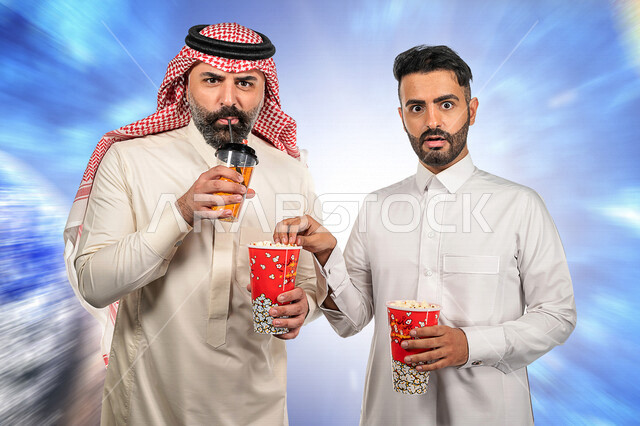 صديقان عربيان سعوديان خليجيان يستمتعان بوقت الفراغ , عطلة نهاية الأسبوع , مشاهدة الأفلام والعروض المسرحية في السنما , الاستمتاع بتناول الفشار أثناء مشاهدة الفلم , إيماءات وجه ويدين مختلفة , خلفية شاشة متحركة.