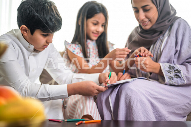 ام عربية خليجية سعودية تقوم بتعليم ابنائها، الانشطة التعليمية، تنمية قدرات الطفل، تعلم وتطور الاطفال، تعليم وتطوير الابناء، رعاية الابناء، الاهتمام بتعليم الابناء