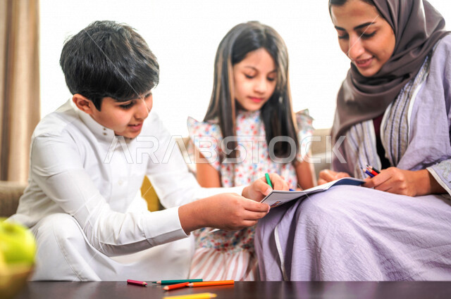 ام عربية خليجية سعودية تقوم بتعليم ابنائها، الانشطة التعليمية، تنمية قدرات الطفل، تعلم وتطور الاطفال، تعليم وتطوير الابناء، رعاية الابناء، الاهتمام بتعليم الابناء