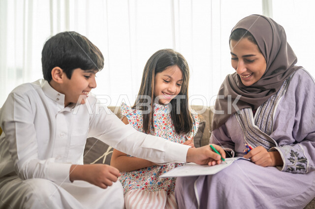 ام عربية خليجية سعودية تقوم بتعليم ابنائها، الانشطة التعليمية، تنمية قدرات الطفل، تعلم وتطور الاطفال، تعليم وتطوير الابناء، رعاية الابناء، الاهتمام بتعليم الابناء