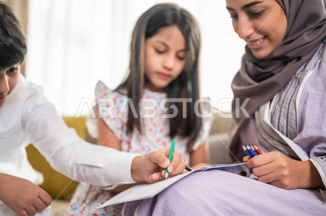 ام عربية خليجية سعودية تقوم بتعليم ابنائها، الانشطة التعليمية، تنمية قدرات الطفل، تعلم وتطور الاطفال، تعليم وتطوير الابناء، رعاية الابناء، الاهتمام بتعليم الابناء