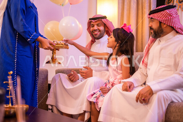 امرأة عربية خليجية سعودية تقوم بتقديم ضيافة العيد، اجواء العائلة السعودية في العيد، فوالة العيد، العيد بين الأهل، بهجه وفرحة العيد، اللمة العائلية، زيارات العيد، الحلوى والقرقيعان، كعك العيد، الاحتفال بالعيد السعيد، أعياد ومناسبات