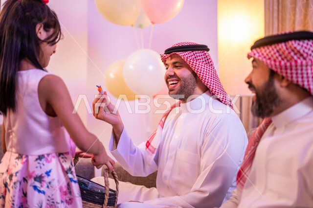 طفلة عربية خليجية سعودية تقوم بتقديم ضيافة العيد، اجواء العائلة السعودية في العيد، فوالة العيد، العيد بين الأهل، بهجه وفرحة العيد، تجمع العائلة، اللمة العائلية، الحلوى والقرقيعان، زيارات العيد، الاحتفال بالعيد السعيد، أجواء عائلية سعيدة، أعياد ومناسبات