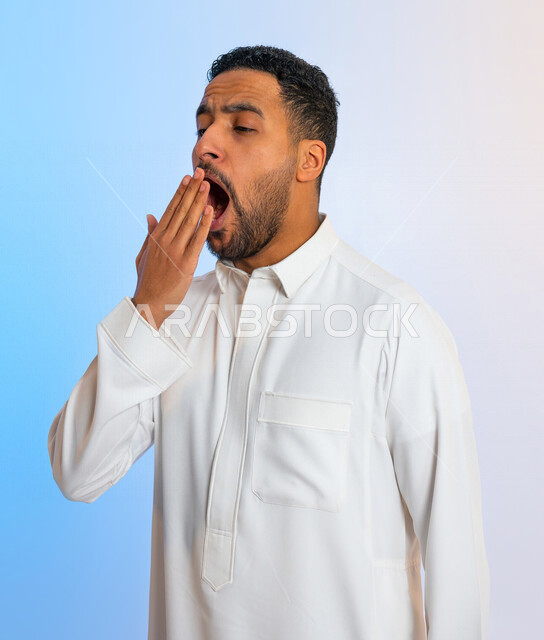 بورتريه لرجل عربي خليجي سعودي يقوم بالتثاؤب ، بايماءات تدل على النعاس ، الكسل والخمول ، التعب والارهاق ، الحاجة الى النوم والراحة 