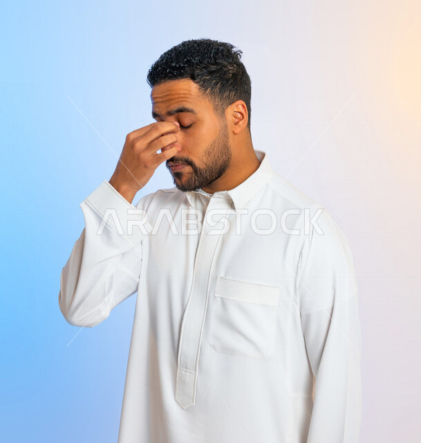 Portrait of a Saudi Arabian Gulf man making hand gestures indicating sadness and the desire to cry, heartbreak and regret, pain in the eyes, loss and failure, frustration