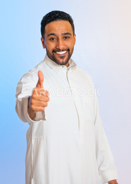 بورتريه لرجل عربي خليجي سعودي يقوم بايماءات يد تدل على الاعجاب بشيء ما، تقييم ايجابي  للخدمات ، شاب يرفع اصبع الابهام لأعلى للرضى وقبول شيء ما