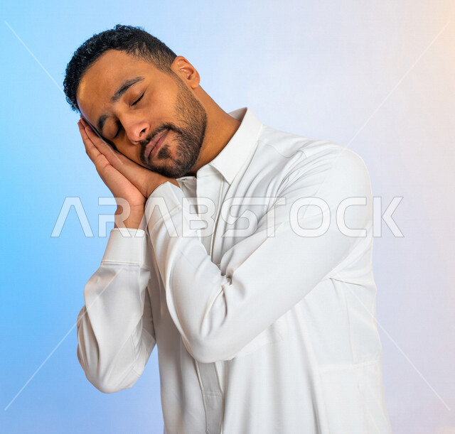 بورتريه لرجل عربي خليجي سعودي ينام على يديه ، ايماءات تدل على النعاس ، الحاجة الى النوم  ، التعب والارهاق ، الكسل والخمول ، النوم بعمق وراحة
