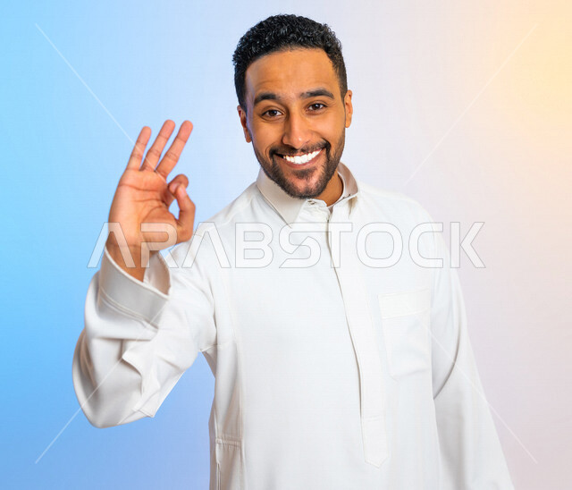 بورتريه لرجل عربي خليجي سعودي مبتسم يقوم بايماءات يد تدل على الاعجاب بشيء ما، تقييم ايجابي  للخدمات ،الرضى والقبول بشيء ما