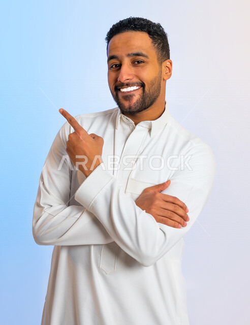 بورتريه لرجل عربي خليجي سعودي ومكتف اليدين، يشير باصبع السبابة الى هدف ما، حركة اصبع واشارات، ايماءات وتعابير الوجه تدل على الفرح والسعادة
