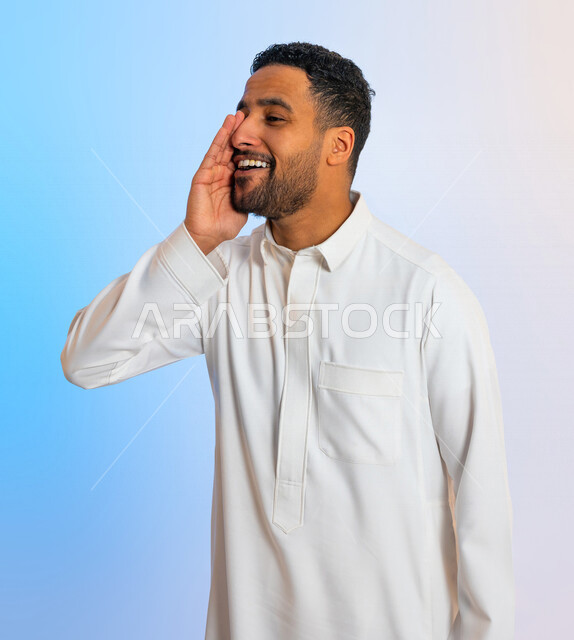 بورتريه لرجل عربي سعودي خليجي يقوم بايماءات تدل على المناداة ، التحدث بصوت منخفض ، مشاركة سر ،الهمس والهدوء اثناء الكلام  