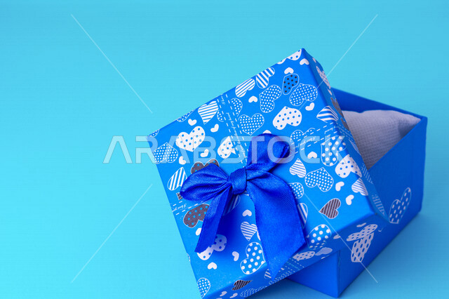 صورة مقربة لعلبة هدايا زرقاء على خلفية زرقاء، أعياد ومناسبات، ديكور وهدايا، عيد الحب.