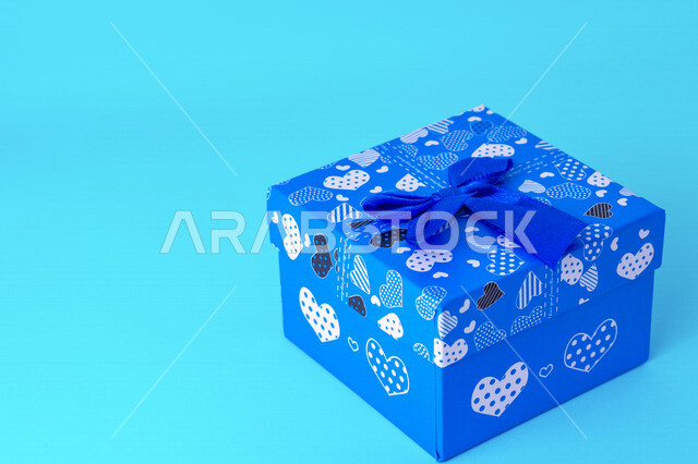 صورة مقربة لعلبة هدايا زرقاء على خلفية زرقاء، أعياد ومناسبات، ديكور وهدايا، عيد الحب.