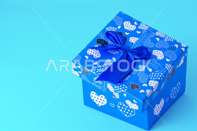 صورة مقربة لعلبة هدايا زرقاء على خلفية زرقاء، أعياد ومناسبات، ديكور وهدايا، عيد الحب.