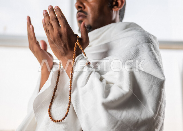 صورة مقربة لرجل عربي سعودي خليجي يرتدي لباس الاحرام و يرفع يديه لاعلى للدعاء والتضرع الى الله ، اداء مناسك الحج والعمرة ، العبادة والتقرب الى الله  ، اداء فريضة الحج ، أذكار وأدعية 