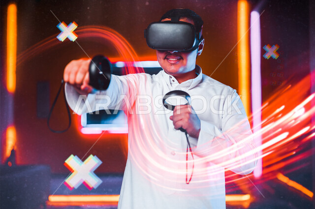 شاب عربي سعودي خليجي يرتدي نظارة العالم الافتراضي, يمسك بيده عصا التحكم و يلعب بألعاب العالم الإفتراضي، المتعة و التسلية بألعاب العالم الإفتراضي, تقنيات و ألعاب, قضاء وقت ممتع, أنشطه ترفيهيه, خلفيات هولوجراميه ثلاثية الأبعاد