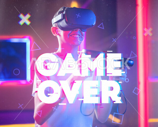 شاب عربي سعودي خليجي يرتدي نظارة العالم الافتراضي, يمسك بيده عصا التحكم و يلعب بألعاب العالم الإفتراضي، المتعة و التسلية بألعاب العالم الإفتراضي, تقنيات و ألعاب, قضاء وقت ممتع, أنشطه ترفيهيه, خلفيات هولوجراميه ثلاثية الأبعاد