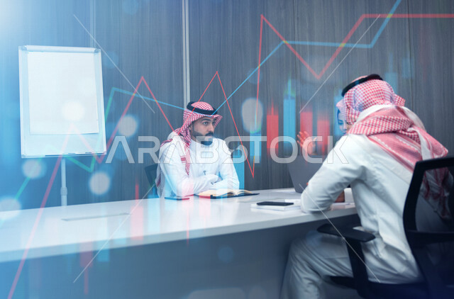 مجموعة من الموظفين الخليجيين السعوديين في اجتماع داخل شركة سعودية ، استخدام الحاسوب المحمول لمتابعة البورصة ،تحليل بيانات المبيعات ومخطط الرسم البياني للنمو الاقتصادي. استراتيجية المال والاعمال ، التسويق الرقمي، خلفية للمخطط البياني