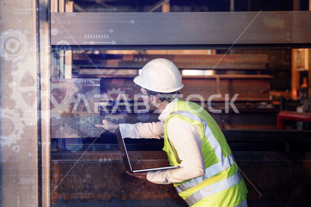 A Saudi Arabian Gulf engineer inside the iron factory, checking the quality of iron through his laptop, using engineering applications and programs, wearing a work helmet and protective jacket, background of a set of gears