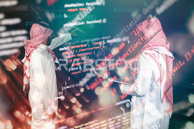 رجلان عربيان خليجيان سعوديان يقفان امام شاشة برموز واكواد برمجية ، استخدام الحاسوب المحمول اثناء العمل ، تصميم وبناء التطبيقات ، تطوير الويب ، انشاء برامج حاسوبية ، حماية الانظمة والشبكات ، خلفية لغة البرمجة 