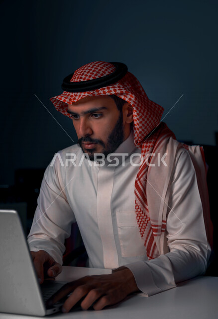رجل عربي خليجي سعودي يستخدم الحاسوب المحمول ، وظيفة مطور ويب، التعليم اونلاين ، العمل عن بعد ، استخدام مواقع التواصل الاجتماعي ،التسويق الالكتروني ، انجاز المهام والاعمال الادارية ، تصفح الانترنت