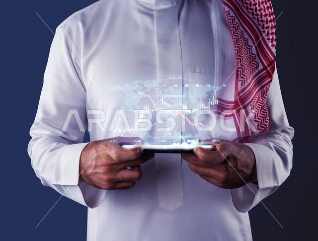 Close-up of the hand of a Saudi Arabian Gulf man using a mobile phone, using 3D hologram technology, stock charts, stock market monitoring, investment and financial trading in the stock market, monitoring the economy and cryptocurrency market