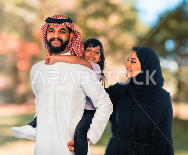 عائلة عربية سعودية خليجية في رحلة رائعة بإحدى الحدائق في المملكة العربية السعودية ، مفهوم الأسرة السعيدة ، قضاء أوقات عائلية ممتعة ، أجواء عائلية سعيدة ، عطلة نهاية الأسبوع ، التسليه والترفيه ، الإستمتاع باجواء العيد مع العائلة