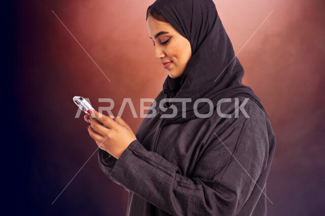 مرأة عربية خليجية سعودية تقوم بإستخدام الهاتف المحمول ، تصفح الانترنت ، إستخدام أجهزة تقنية حديقة ، التسويق الإلكتروني ، العمل عن بعد ، التواصل مع الأصدقاء ، قضاء أوقات ممتعة