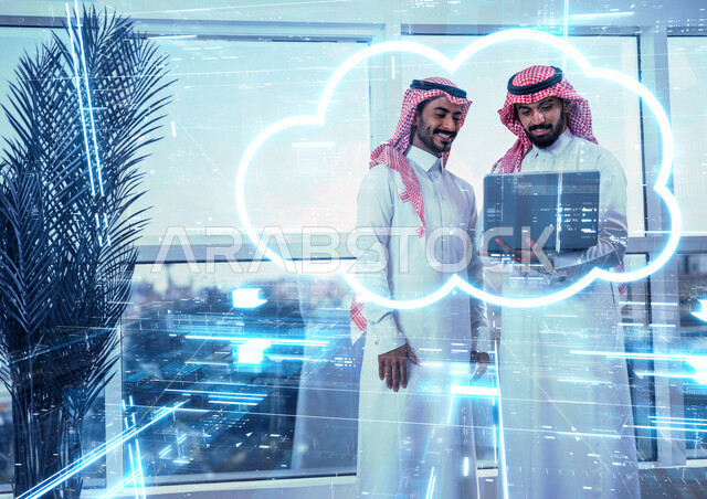 موظفان عربيان خليجيان سعوديان يستخدمان الحاسوب المحمول، سحابة إلكترونية بإستخدام تقنية الهولوجرام ثلاثية الأبعاد ، مهن ووظائف ، دراسة المشاريع ، السحابة الإلكترونية