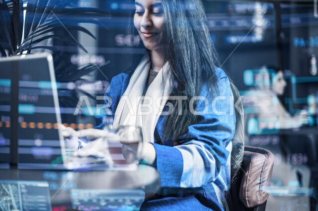 شابة عربية خليجية سعودية، تقوم بإستخدام جهاز الحاسوب المحمول، العمل عن بعد، جلسة عمل، مجموعة من الأرقام والقوانين الرياضية بتقنية الهولوجرام ثلاثية الأبعاد، قياس أرباح الأعمال، إدارة العمليات التجارية، وظيفة محاسبة، حساب التكاليف والمصروفات