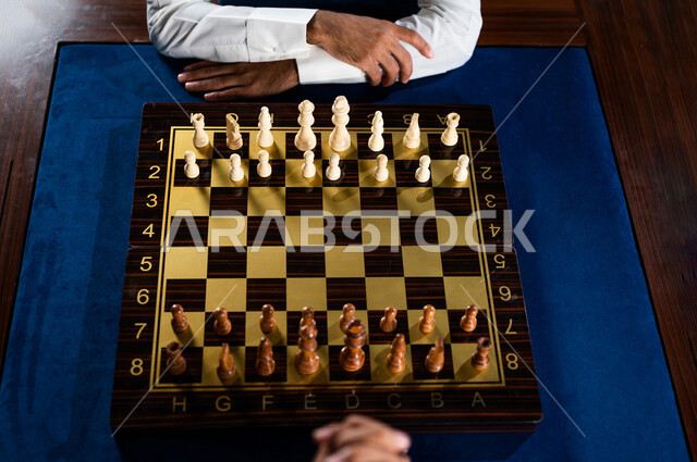 صورة مقربة لشابان عربيان سعوديان خليجيان يلعبان لعبة الشطرنج, مفهوم التركيز و التحدي, التخطيط والتفكير, لعبة رقمية استراتيجية على رقعة الشطرنج, أنشطه ترفيهيه, قضاء وقت ممتع, تسليه وترفيه