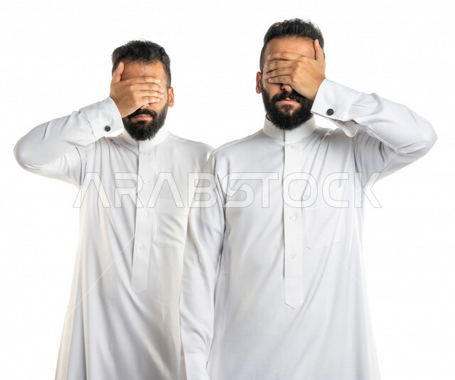  بورتريه لرجلان توأم عربيان خليجيان سعوديان يضعان يدهما على عينيهما ، تجنب رؤية شيء ما ، اخفاء ملامح الوجه ، اخفاء الحقائق ، خلفية بيضاء
