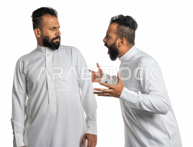 بورتريه لرجلان توأم عربيان خليجيان سعوديان يقفان مقابل بعضهم ، الغضب والقاء اللوم ، النقاش والمواجهة ، التعصب والتوتر ، اساءة الظن ، نقاش حاد ، خلفية بيضاء