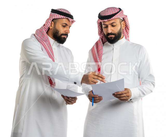 بورتريه لرجلان توأم عربيان خليجيان سعوديان، مناقشة عمل، اجتماع زملاء العمل في مقر عملهم، تطوير العمل وحل المشكلات، توزيع مهام العمل، الوحده والعمل الجماعي، تطوير أهداف الشركة، اتفاقية عمل، بيئة عمل سعودية، خلفية بيضاء