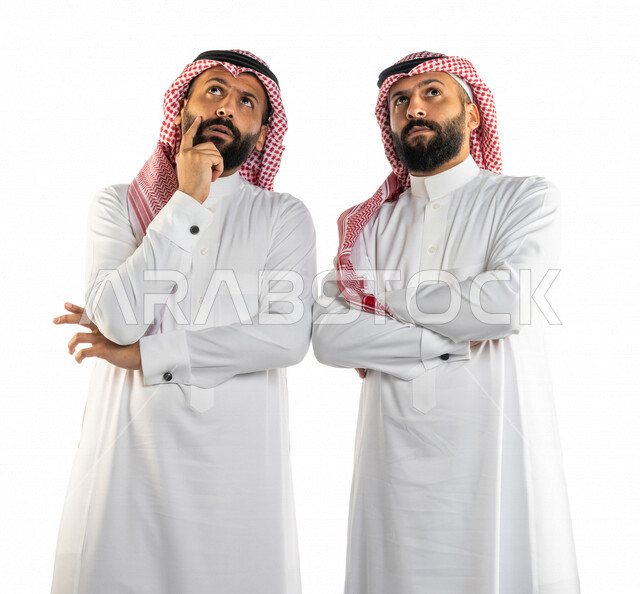 بورتريه لرجلان توأم عربيان خليجيان سعوديان، التفكير بالمستقبل، التمعن والتركيز وحل المشكلات، اتخاذ القرارات، التمعن في حل مشكلة، الحيرة والتفكير، ايجاد الحلول، ايماءات وجه ويدين تدل على التفكير والحيرة، خلفية بيضاء