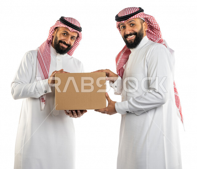 بورتريه لرجلان توأم عربيان خليجيان سعوديان يحملان صندوق كرتوني، الاستمتاع بالشراء والتسوق، خدمة توصيل الطرود للزبائن، ايماءات وجه مبتسمة، خلفية بيضاء