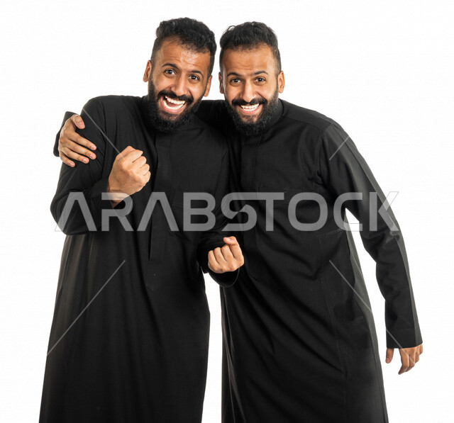بورتريه لرجلان توأم عربيان خليجيان سعوديان، الفرح بالفوز والانتصار، النجاح والقوة، تحقيق الاهداف، السعادة بالفوز، ايماءات وجه ويدين تدل على التشجيع والحماس، خلفية بيضاء