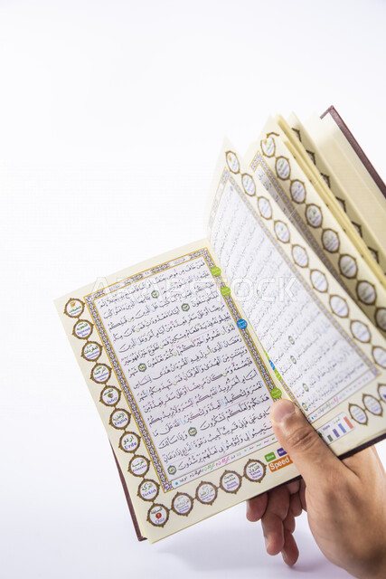 صورة ليد رجل يمسك المصحف الشريف , تلاوة وحفظ القران الكريم , التدبر والخشوع , حلقات القرآن , رمضان , إسلاميات وعبادة .
