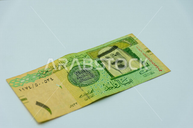 صورة لورقة نقدية من فئة 1 ريال سعودي من الإصدار الخامس، صورة الملك عبد الله بن عبد العزيز ال سعود مطبوعة على عملة الريال السعودي، عملة ورقية، مالية واقتصاد، العملة الرسمية للسعودية، خلفية بيضاء