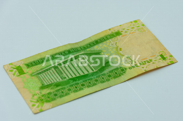 صورة من الخلف لورقة نقدية من فئة 1 ريال سعودي من الإصدار الخامس، عملة الريال السعودي، التمويل والاستثمار، عملة ورقية، مالية واقتصاد، العملة الرسمية للسعودية، خلفية بيضاء