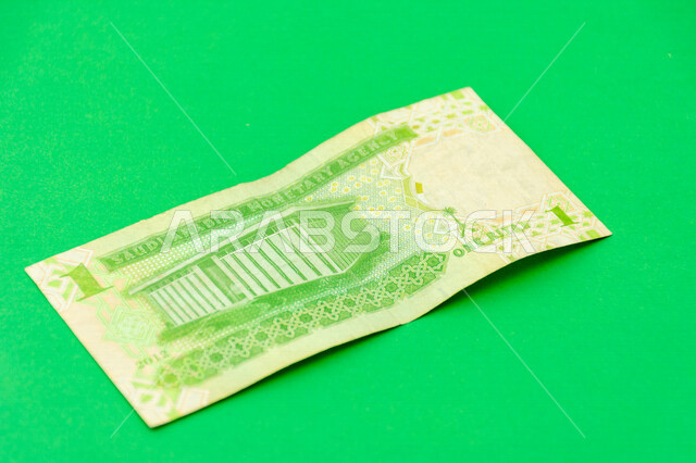 صورة من الخلف لورقة نقدية من فئة 1 ريال سعودي من الإصدار الخامس، عملة الريال السعودي، التمويل والاستثمار، عملة ورقية، مالية واقتصاد، العملة الرسمية للسعودية، خلفية خضراء