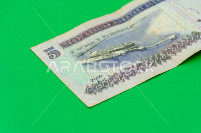 صورة من الخلف لورقة نقدية من فئة 5 ريال سعودي من الإصدار الخامس، عملة الريال السعودي، التمويل والاستثمار، عملة ورقية، مالية واقتصاد، العملة الرسمية للسعودية، خلفية خضراء