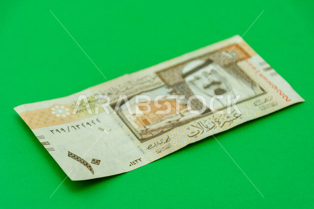 صورة لورقة نقدية من فئة 10 ريال سعودي من الإصدار الخامس، صورة الملك عبد الله بن عبد العزيز ال سعود مطبوعة على عملة الريال السعودي، عملة ورقية، مالية واقتصاد، العملة الرسمية للسعودية، خلفية خضراء