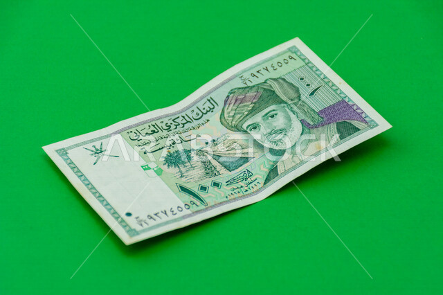 صورة لورقة نقدية من فئة 100 بيسة عمانية، صورة السلطان قابوس بن سعيد بن تيمور آل سعيد مطبوعة على عملة البيسة العمانية، عملة ورقية، البنك المركزي العماني، العملة الرسمية لسلطنة عمان، خلفية خضراء