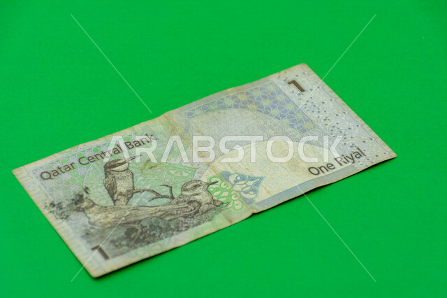 صورة من الخلف لورقة نقدية من فئة 1 ريال قطري، صورة لثلاثة طيور مطبوعة على عملة الريال القطري، عملة ورقية، مصرف قطر المركزي، العملة الرسمية لدولة قطر، خلفية خضراء